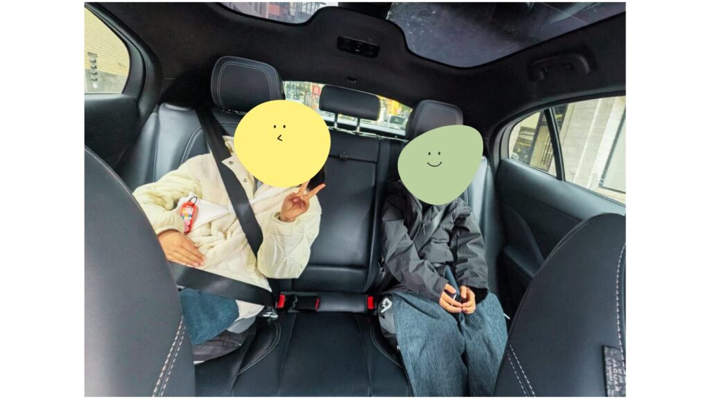 waymoの中で子どもたちピースしている写真